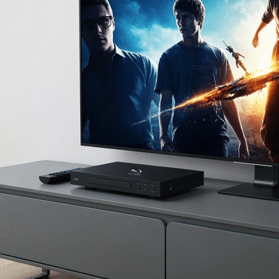 Modern Blu-ray player with remote on a sleek media console, showing a vibrant movie scene on a TV, no text, no words, no typography, clean image